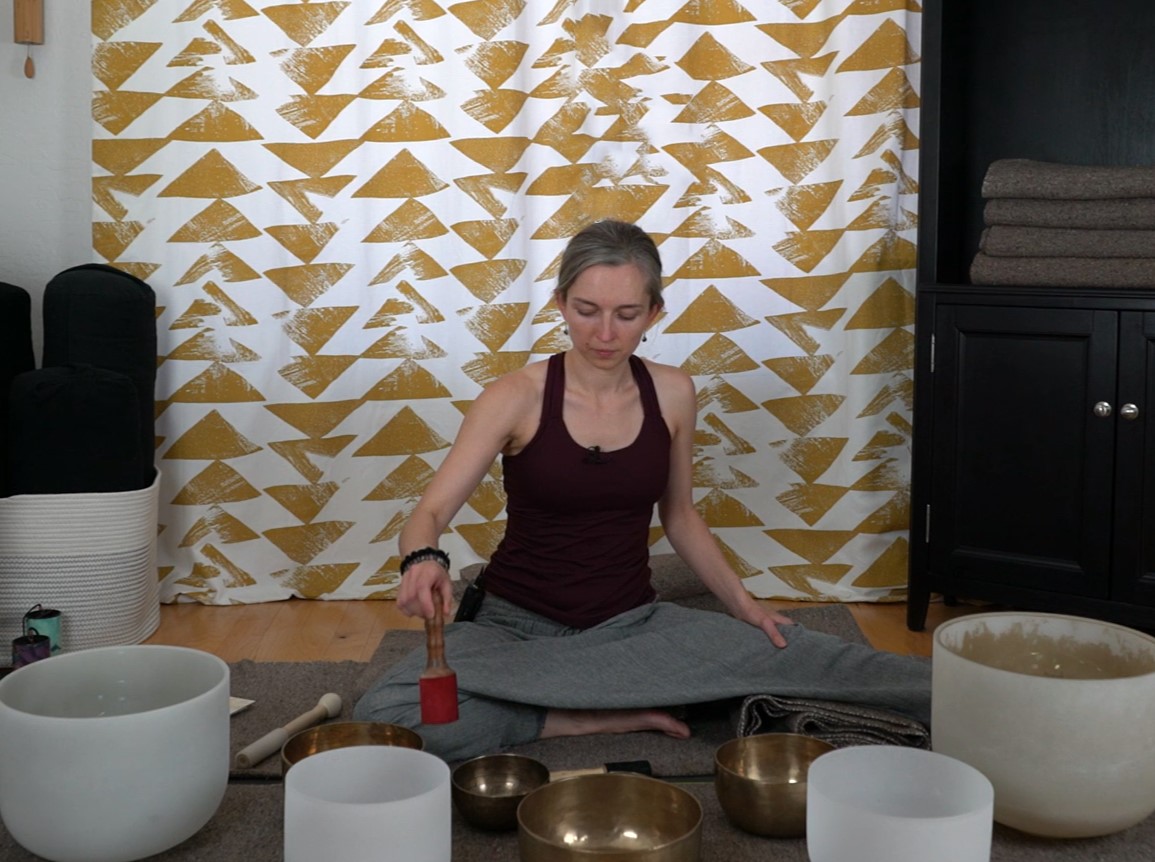 Veda playing a variety of sound healing instruments including bowls and gongs